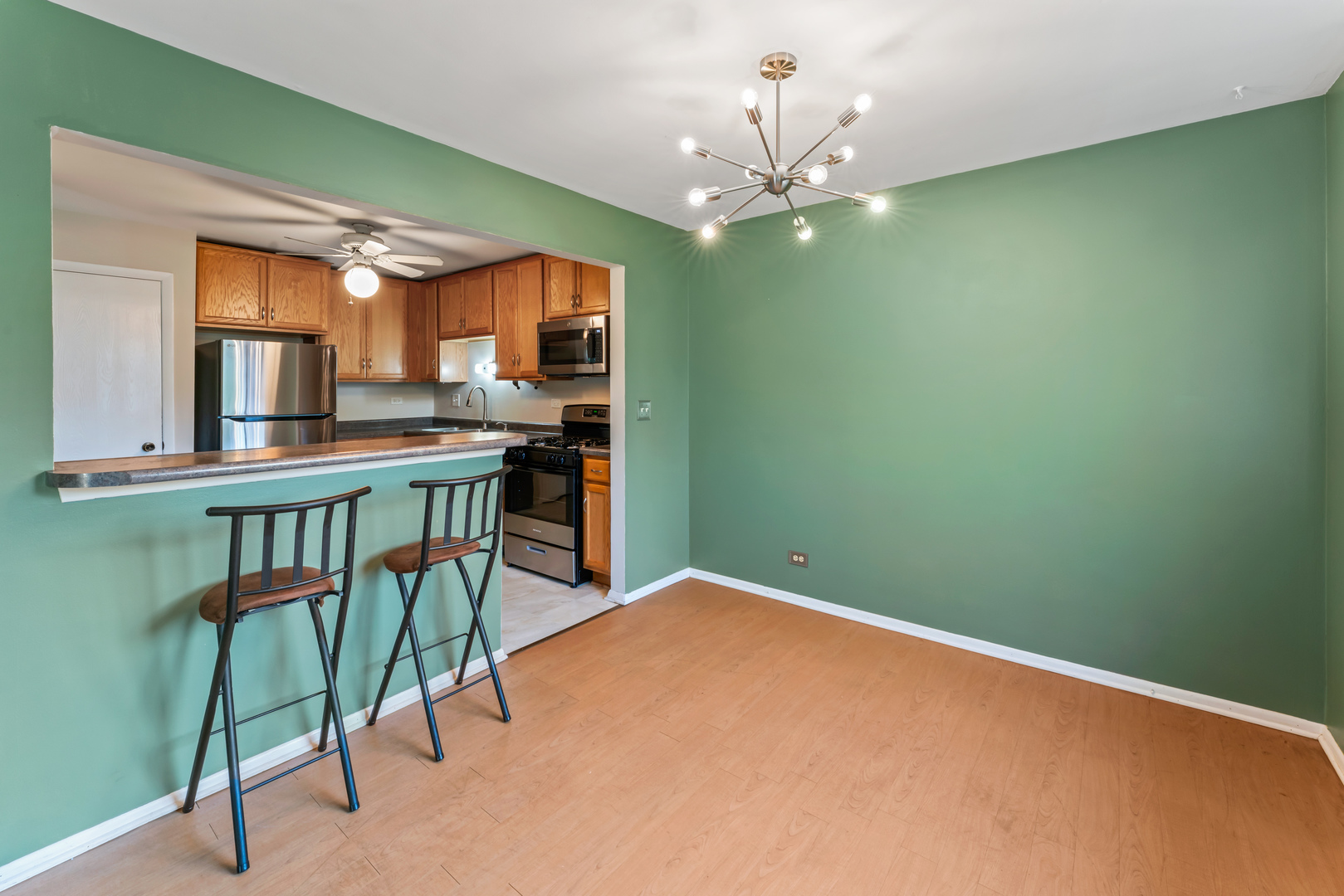 601 Hanover Court, Unit Z2 Schaumburg, IL 60194 - Photo 4 of 22 a workspace with chandelier fan and a wooden floor