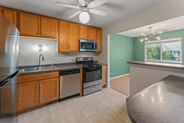 a kitchen with stainless steel appliances granite countertop a stove a sink and a microwave