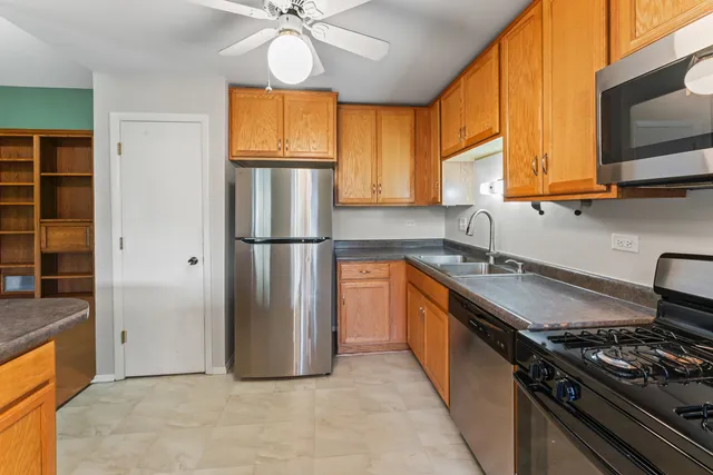 a kitchen with stainless steel appliances granite countertop a refrigerator a sink and a stove