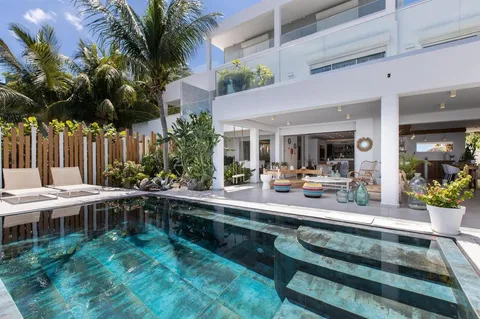 a patio with a table and chairs and potted plants