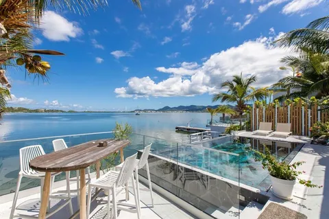 a view of a chairs and table in patio with a lake view