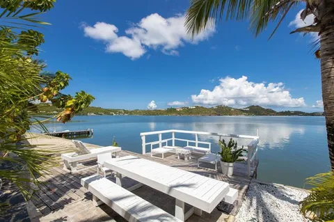 a roof deck with table and chairs and potted plants
