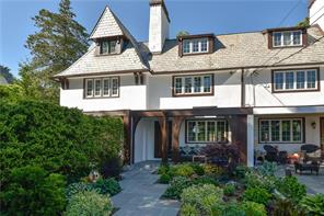 a view of a white house with large windows and a small yard
