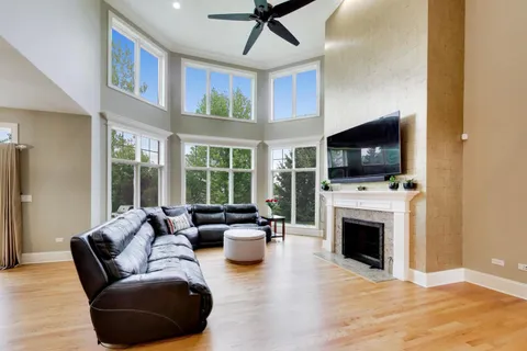 a living room with furniture a flat screen tv and a floor to ceiling window