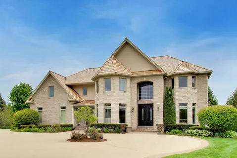 a front view of a house with yard and green space