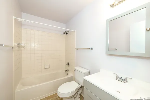 a bathroom with a bathtub shower sink vanity and toilet