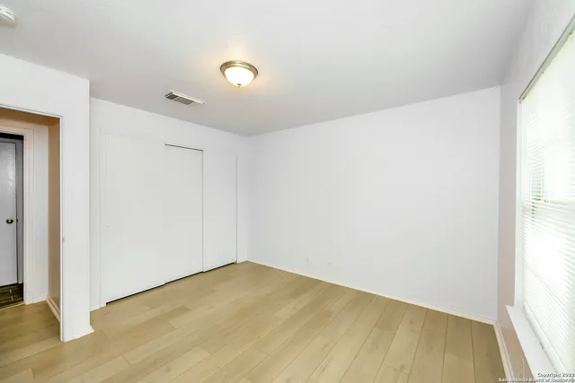a view of empty room with wooden floor
