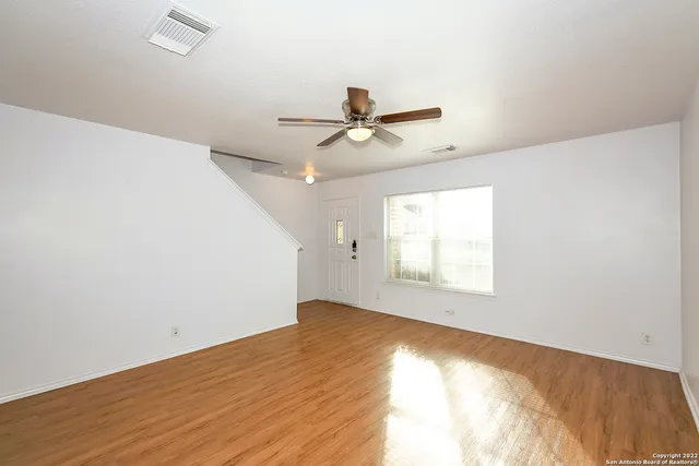 an empty room with a window and a ceiling fan