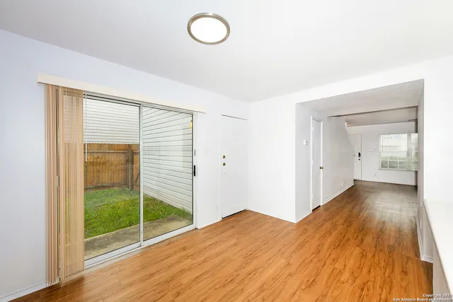a view of a room with wooden floor and sliding glass door