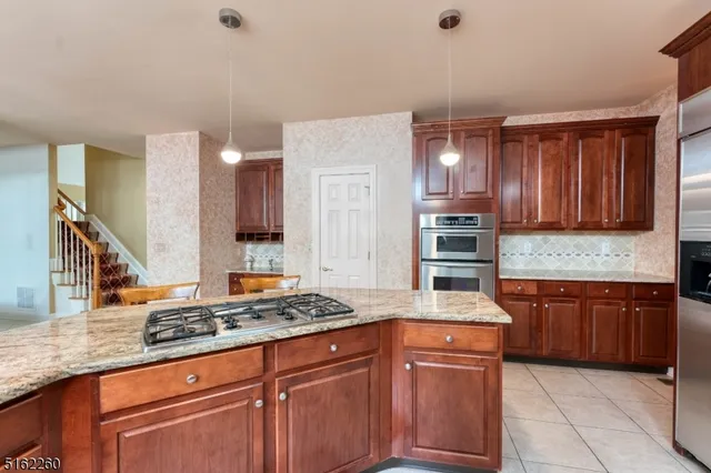 a kitchen with stainless steel appliances granite countertop a stove sink and cabinets