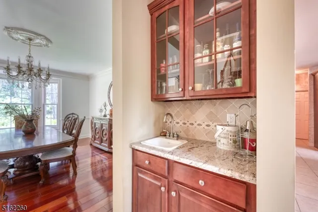 a kitchen with stainless steel appliances granite countertop a table chairs in it and wooden floors