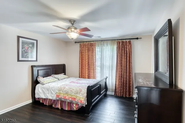 a bedroom with a bed and a large window with wooden floor
