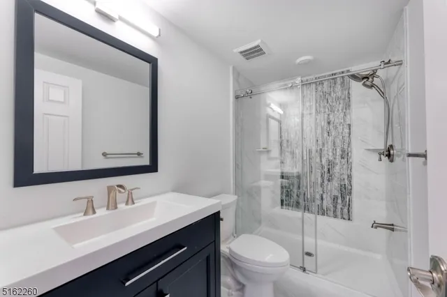 a bathroom with a sink toilet a mirror and shower