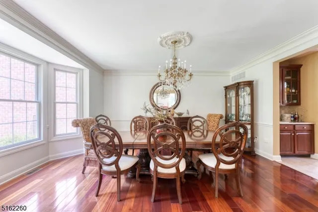 a view of a dining room with furniture a chandelier and wooden floor