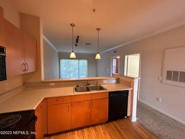a kitchen with a sink cabinets and wooden floor
