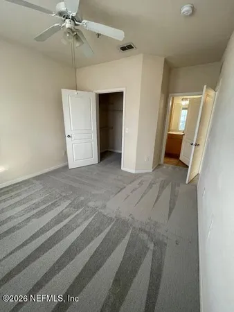 a view of a hallway with wooden floor and a bathroom