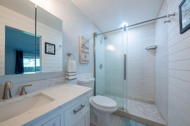 a bathroom with a sink toilet a mirror and shower