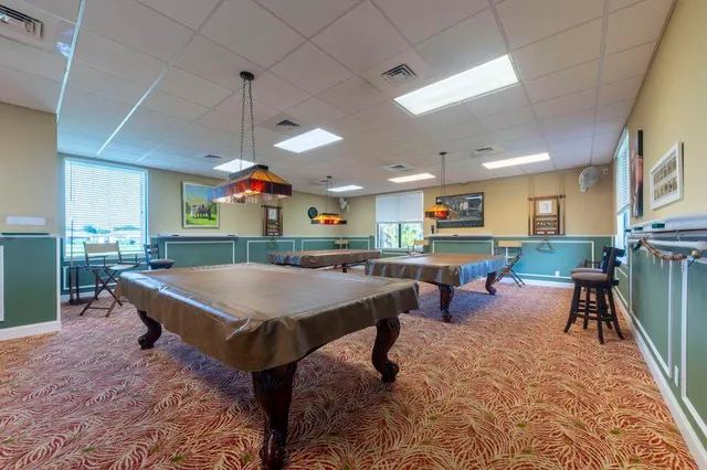 a room with furniture pool table and wooden floor