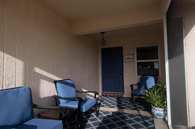 a view of a hallway with chairs and a potted plant