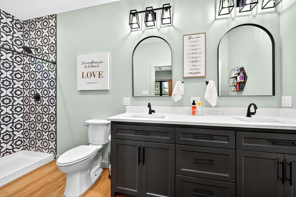 1838 Richerson Road Denison, TX 75021 - Photo 16 of 40 a bathroom with a toilet a sink and mirror