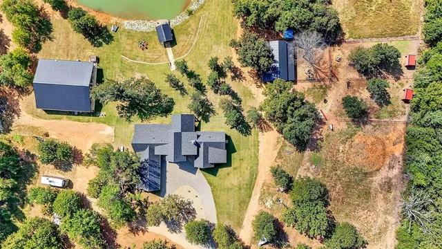 an aerial view of lake residential house with outdoor space and trees all around