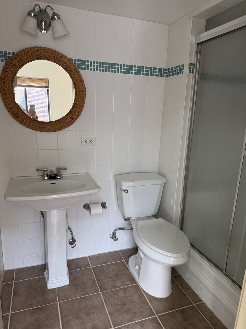 383 Wilmington Drive, Unit E Bartlett, IL 60103 - Photo 11 of 17 a bathroom with a sink toilet and a mirror