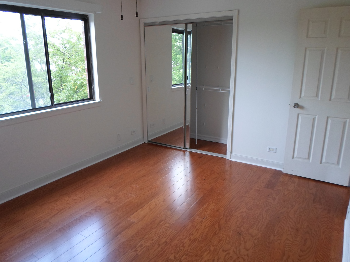 383 Wilmington Drive, Unit E Bartlett, IL 60103 - Photo 13 of 17 an empty room with wooden floor and windows