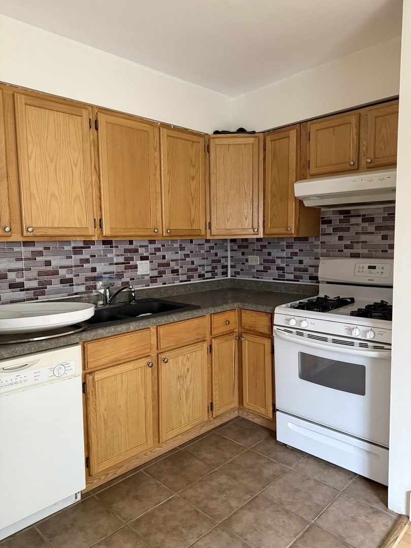 383 Wilmington Drive, Unit E Bartlett, IL 60103 - Photo 5 of 17 a kitchen with stainless steel appliances granite countertop a stove a sink and a microwave