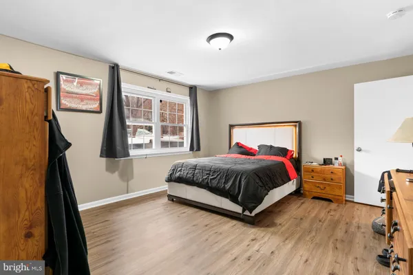 a spacious bedroom with a bed and wooden floor