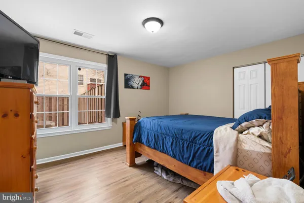 a bedroom with a bed and wooden floor