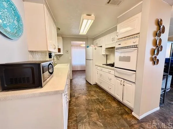 a kitchen with stainless steel appliances kitchen island granite countertop a refrigerator and a stove top oven