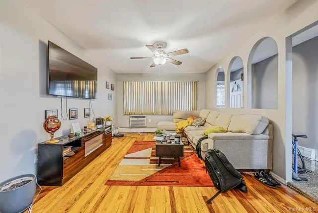 a living room with a bed furniture and a flat screen tv