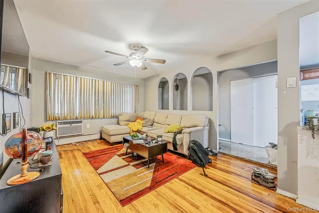 a living room with furniture a flat screen tv and a window