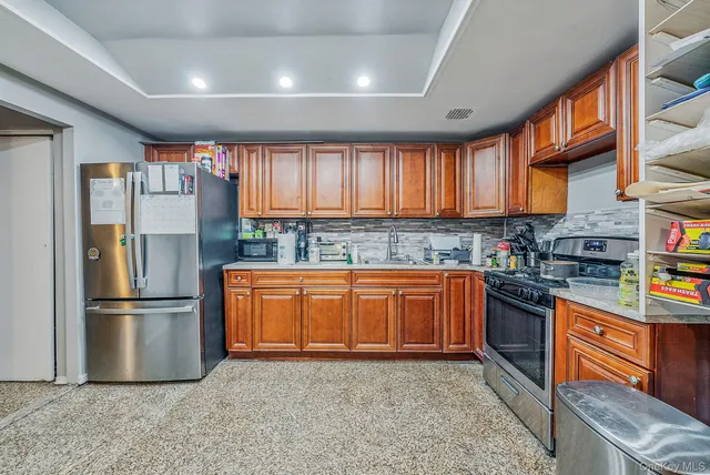 a kitchen with stainless steel appliances granite countertop a refrigerator stove top oven a sink and dishwasher