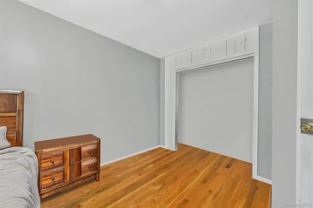 a bedroom with a bed and a flat tv screen on a dresser