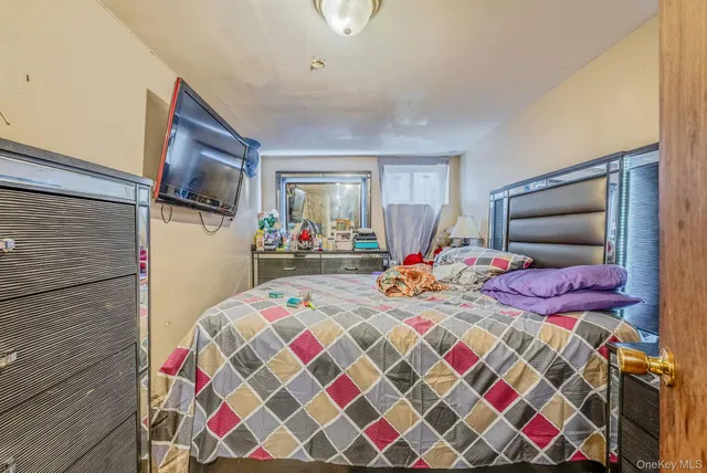 a bedroom with bed and a flat screen tv