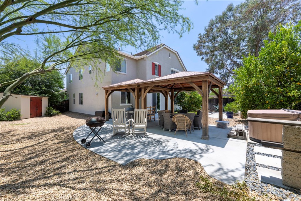 3819 St Austell Way Perris, CA 92571 - Photo 53 of 64 a patio with a table and chairs under an umbrella