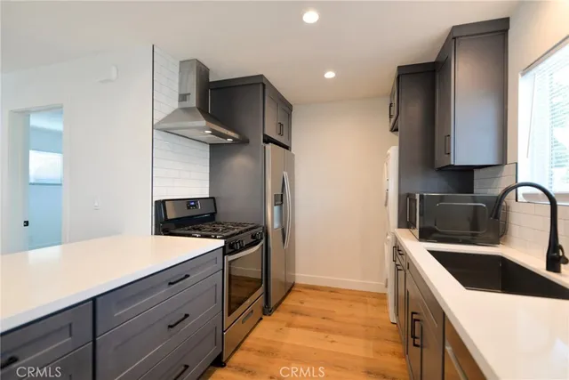 a kitchen with stainless steel appliances a stove a sink and a refrigerator