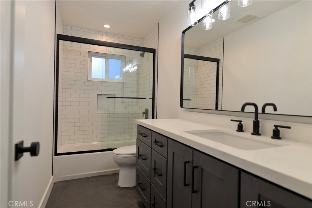 223 Avenida De La Grulla, Unit B San Clemente, CA 92672 - Photo 7 of 11 a bathroom with a granite countertop sink a toilet a mirror and shower