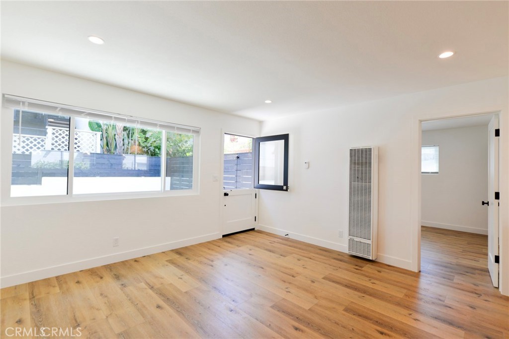 223 Avenida De La Grulla, Unit B San Clemente, CA 92672 - Photo 10 of 11 an empty room with wooden floor and windows