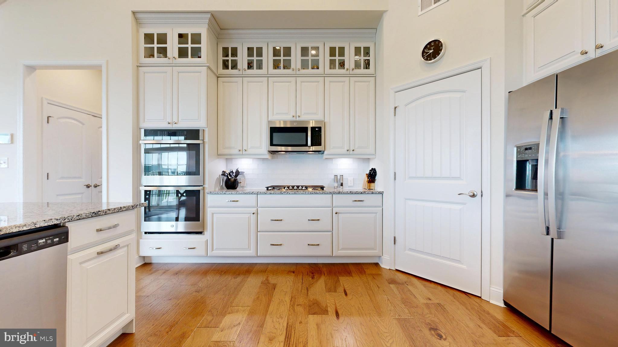 33528 Downing Circle Lewes, DE 19958 - Photo 19 of 72 a kitchen with white cabinets and black appliances