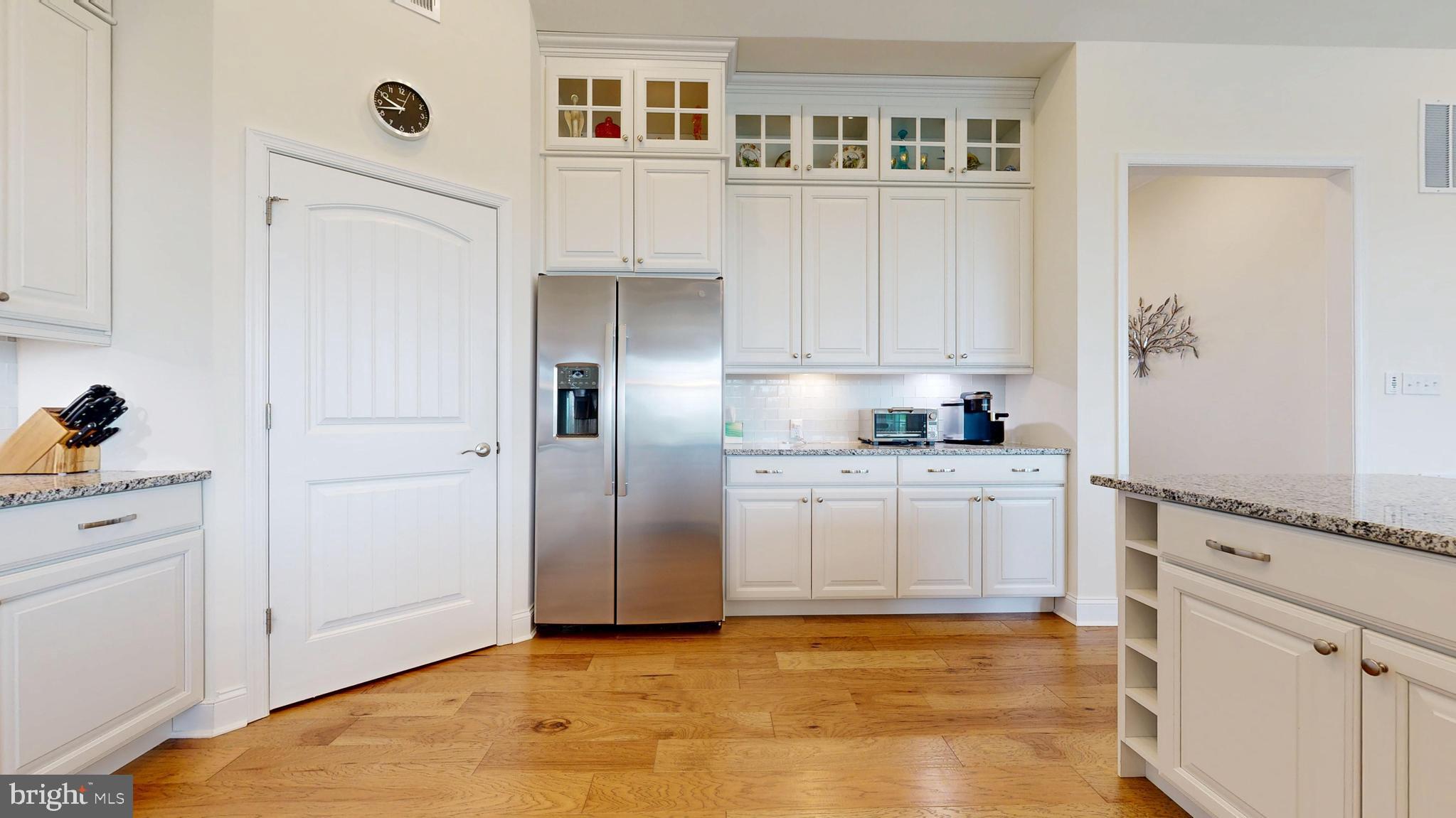 33528 Downing Circle Lewes, DE 19958 - Photo 20 of 72 a kitchen with granite countertop white cabinets and refrigerator