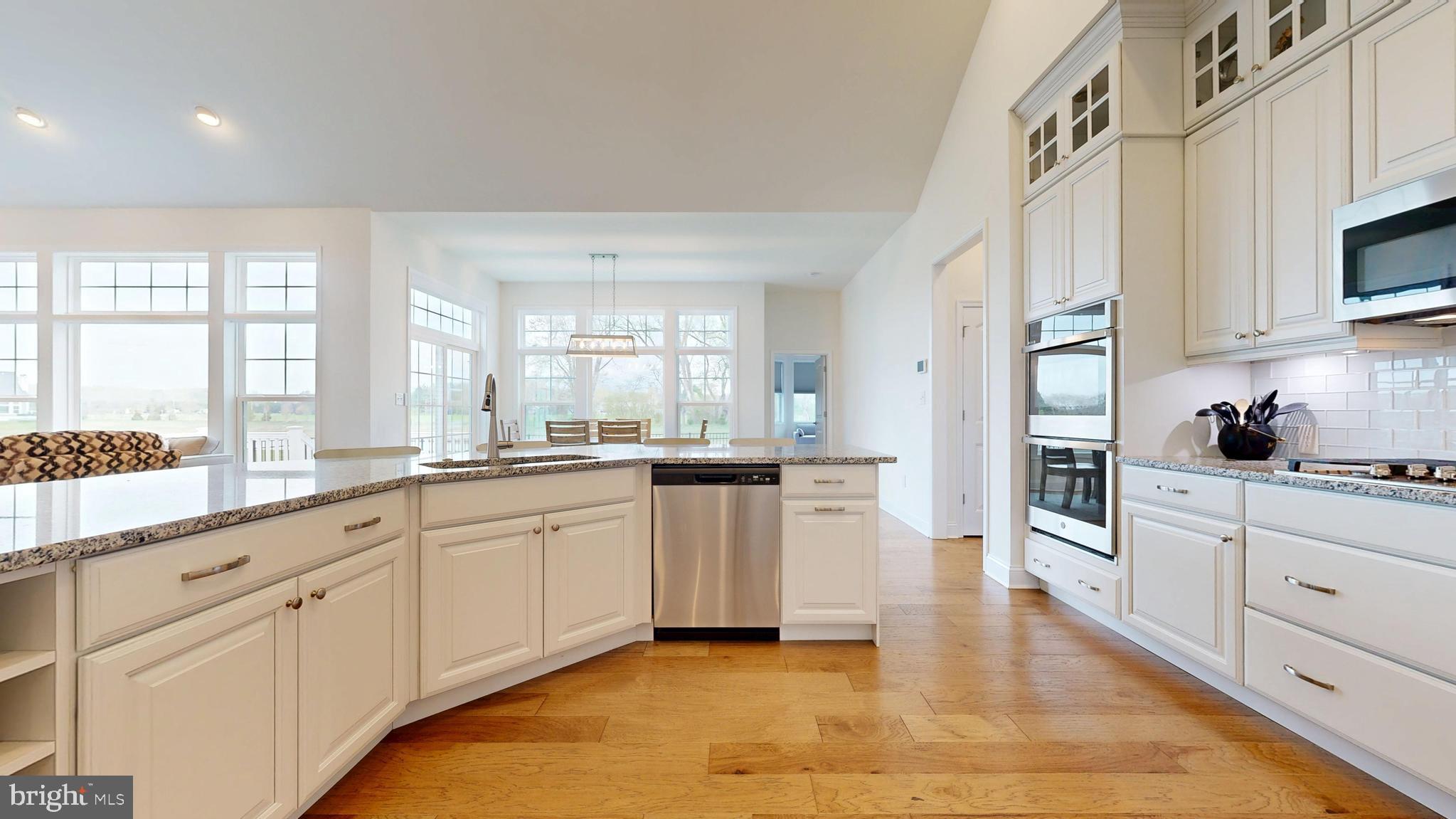 33528 Downing Circle Lewes, DE 19958 - Photo 22 of 72 a large kitchen with cabinets and wooden floor