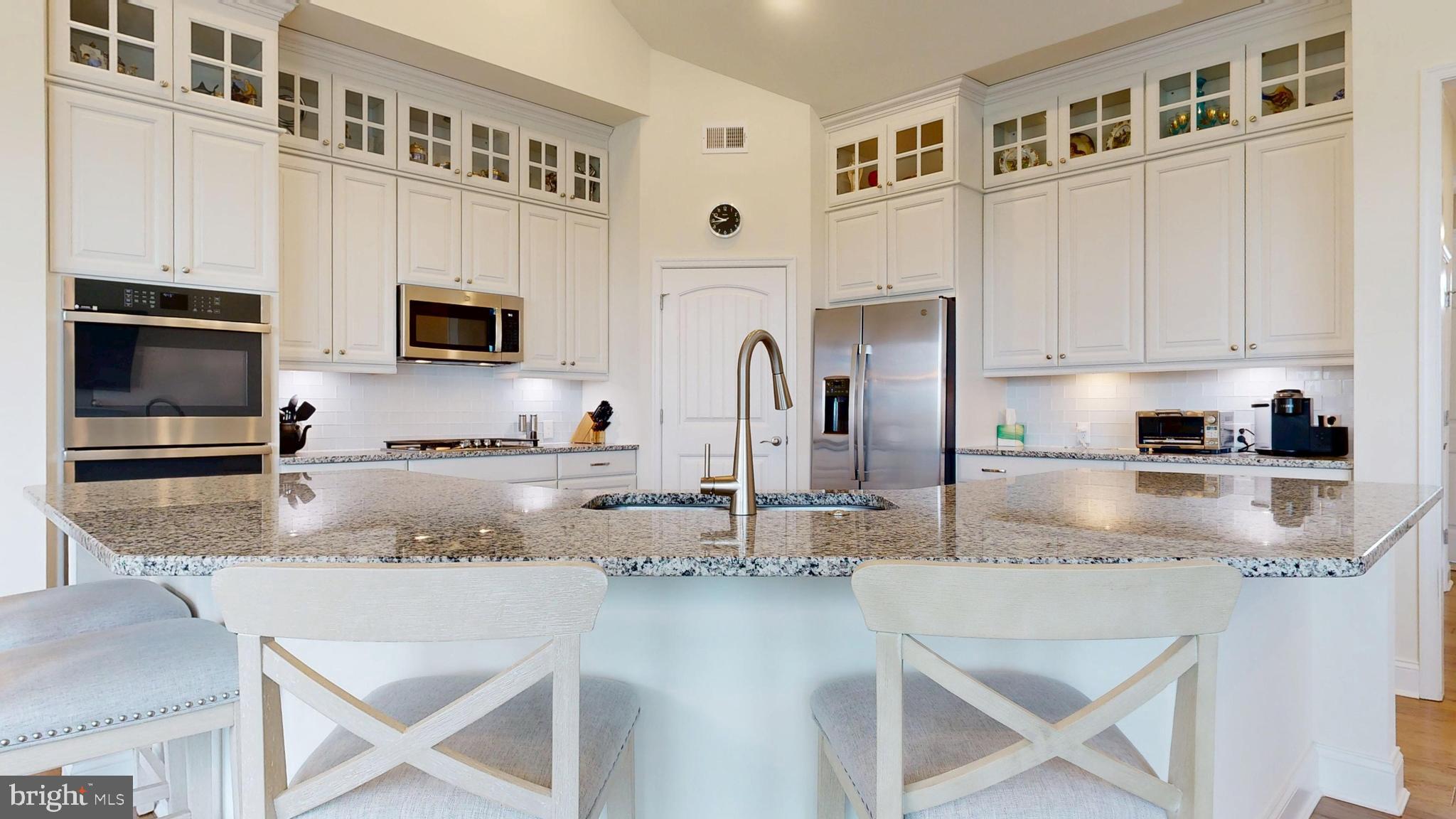 33528 Downing Circle Lewes, DE 19958 - Photo 23 of 72 a kitchen with stainless steel appliances granite countertop a stove top oven a sink a refrigerator with white cabinets and granite countertops