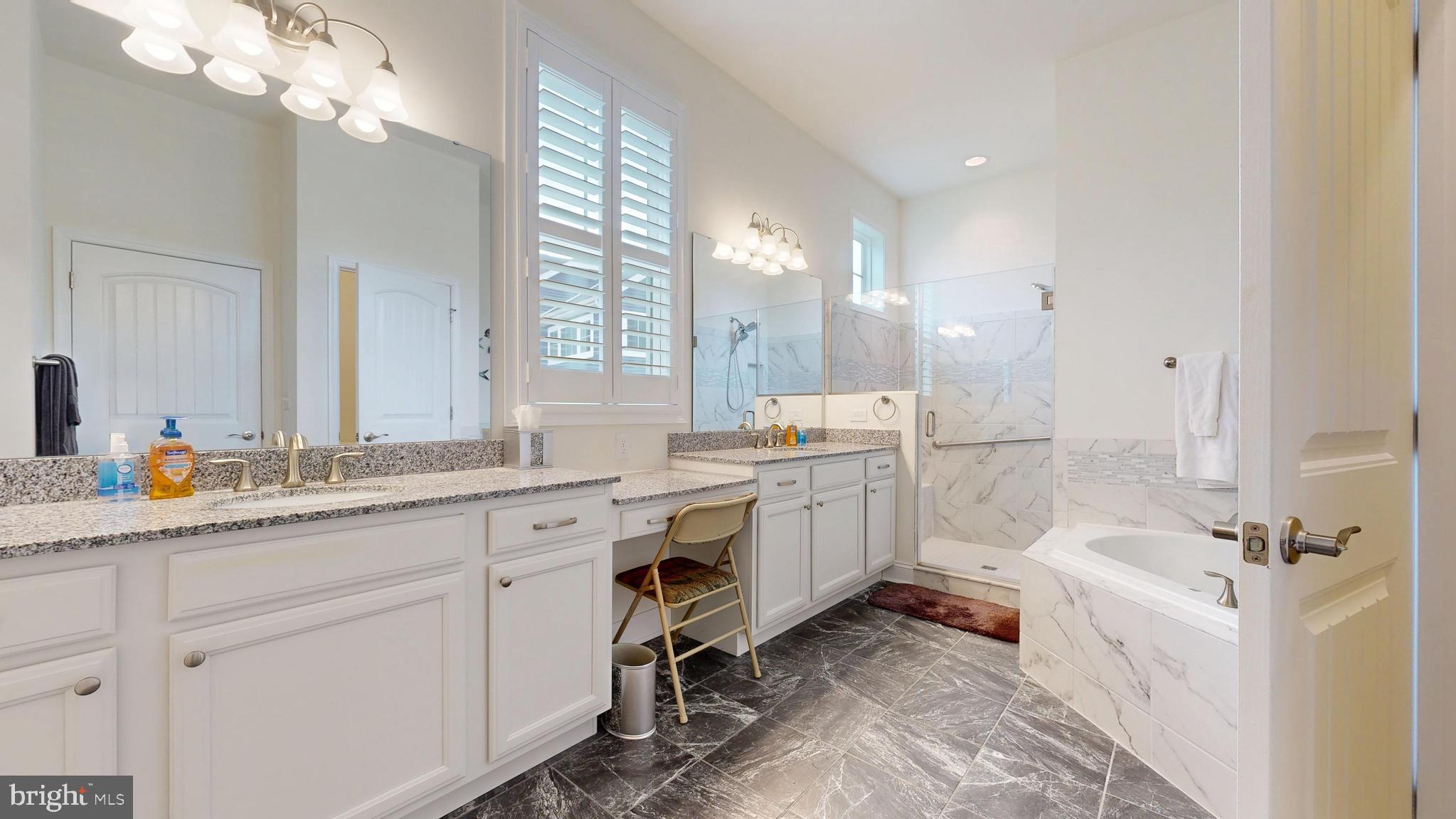 33528 Downing Circle Lewes, DE 19958 - Photo 34 of 72 a spacious bathroom with a double vanity sink a mirror a bathtub and window