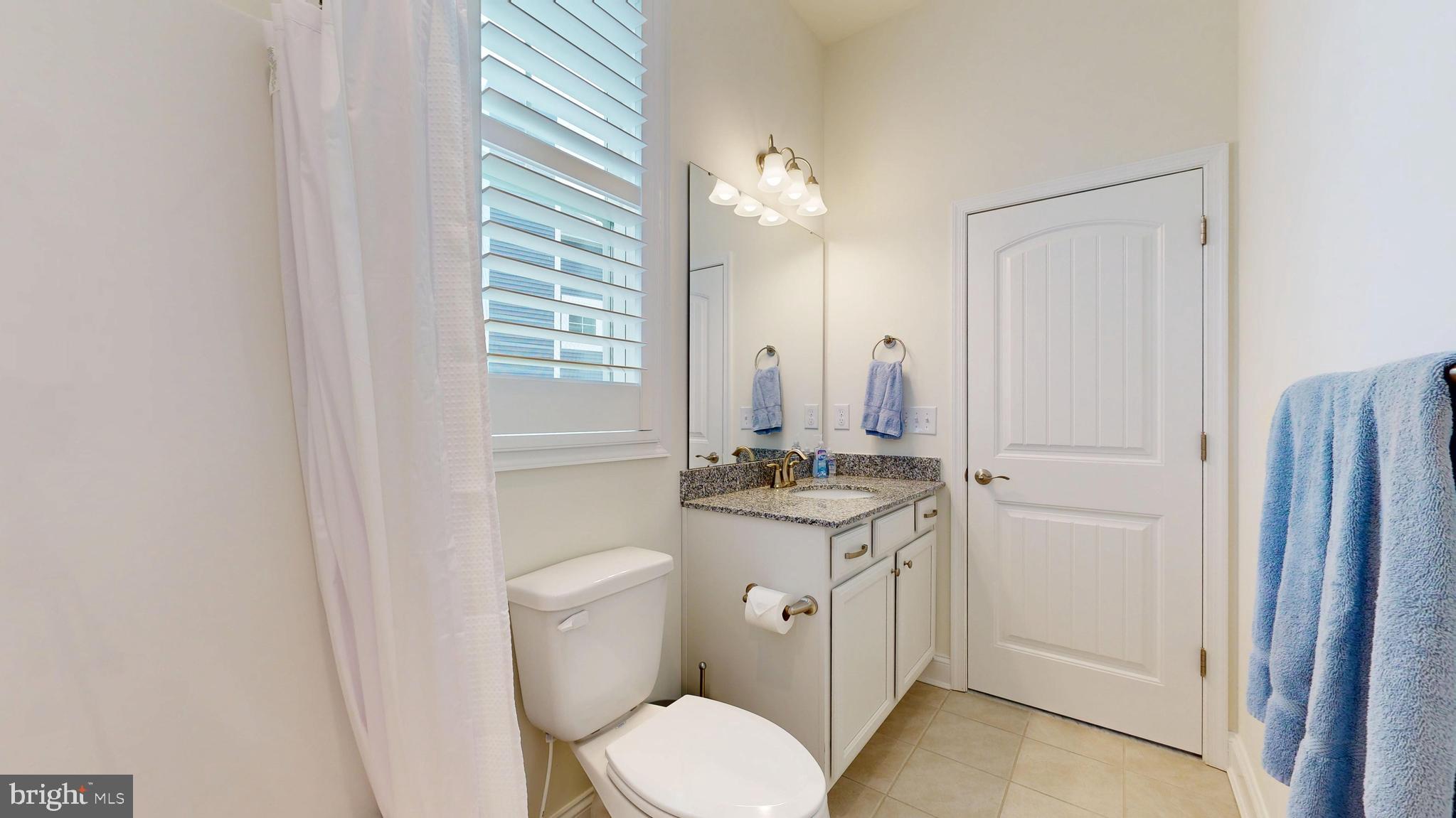 33528 Downing Circle Lewes, DE 19958 - Photo 54 of 72 a bathroom with a granite countertop toilet a sink and a mirror