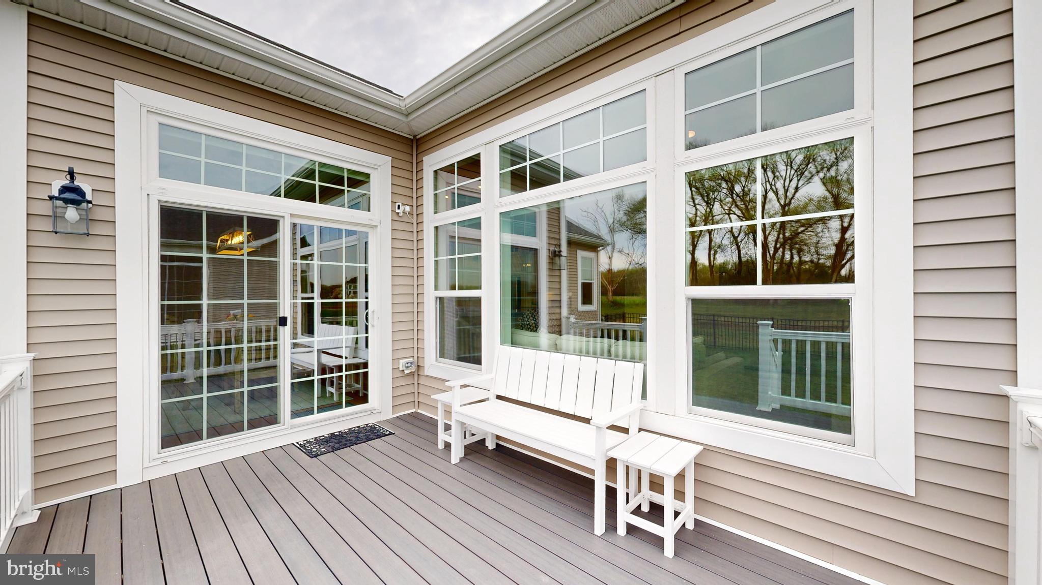 33528 Downing Circle Lewes, DE 19958 - Photo 8 of 72 a view of a balcony with wooden floor and floor to ceiling window