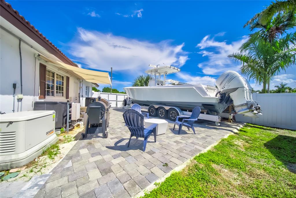 250 Northeast 27th Court Boca Raton, FL 33431 - Photo 14 of 29 a view of a patio with table and chairs potted plants and a palm tree