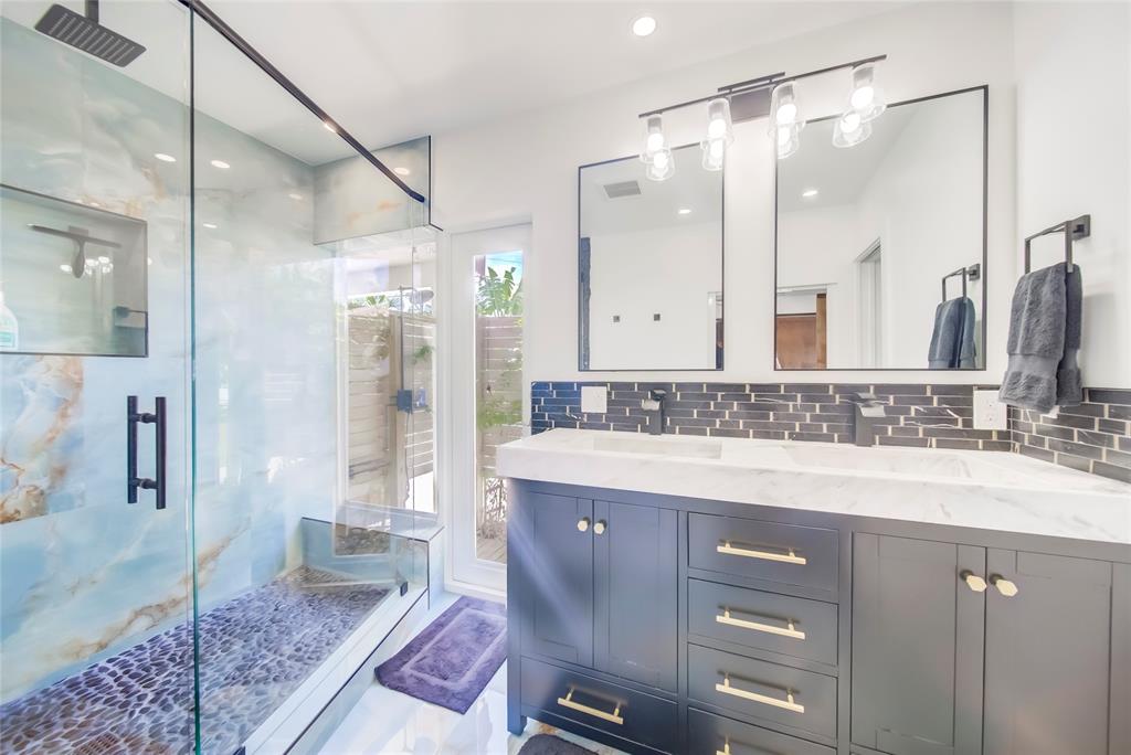 250 Northeast 27th Court Boca Raton, FL 33431 - Photo 21 of 29 a bathroom with a granite countertop sink a mirror and a shower