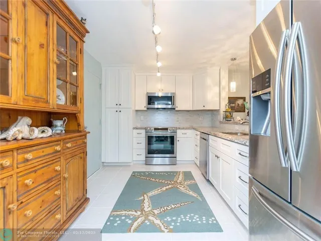 a dining room with wooden floor a chandelier a wooden table and chairs